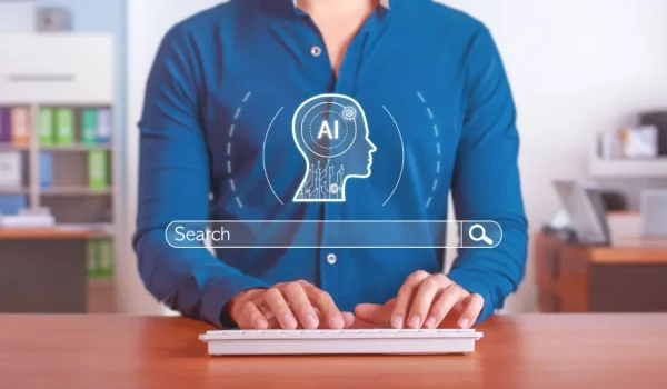 Osoba pri počítači s vizuálom umelej inteligencie a vyhľadávacieho poľa pri optimalizácii webstránky.